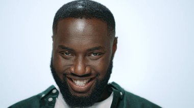 Gri arka planda komik suratlar yapan heyecanlı Afrikalı Amerikalı adamın yakın çekimi..