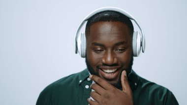 Stüdyoda kulaklıkla müzik dinleyen Afrikalı bir adamın portresi..