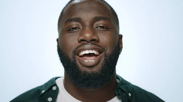 Retrato del hombre afroamericano emocional sonriendo sobre fondo claro. —  Fotos de Stock