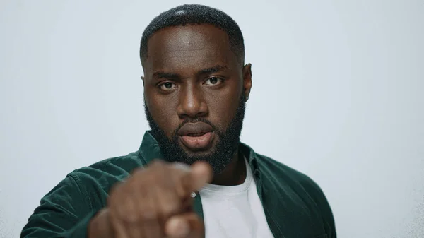 Portret van een serieuze Afro-Amerikaanse man wijzende vinger op lichte achtergrond. — Stockfoto