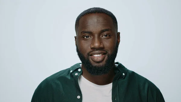 Retrato del guapo africano sonriente levantando la cabeza en un fondo gris. — Foto de Stock