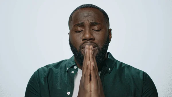 Retrato del hombre afroamericano rezando sobre fondo gris. Concepto de meditación —  Fotos de Stock