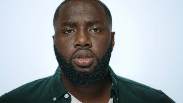 Portret van een knappe Afro-Amerikaanse man die baard checkt in een lichte achtergrond. — Stockfoto