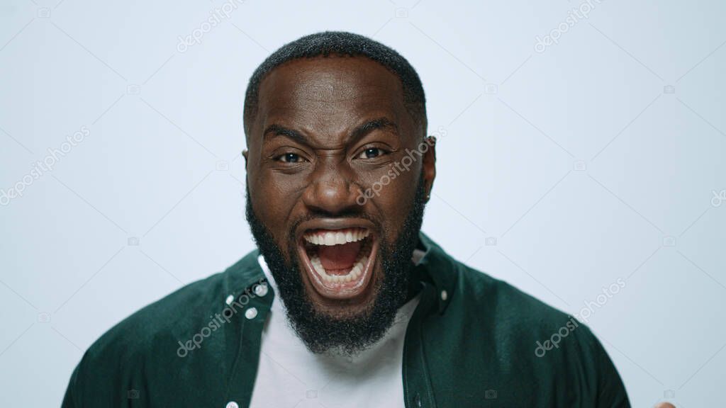 Portrait of scared african man posing with positive emotion in studio.
