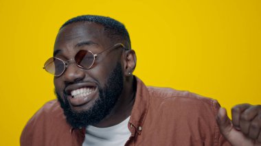 Sarı arka planda dans eden Afrikalı Amerikalı adamın portresi..