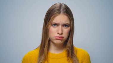 Stüdyoda gri arka planda para sayan üzgün kadının portresi..