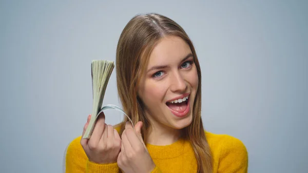 Portret van een gelukkige vrouw die geniet van dollarbiljetten in de studio. — Stockfoto