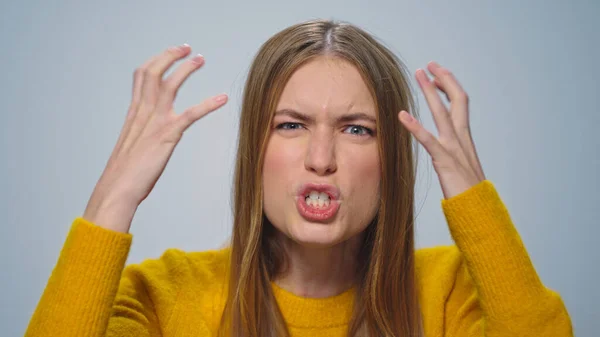 Portrait of angry woman screaming with aggressive emotion at camera in studio. — Stock Photo, Image