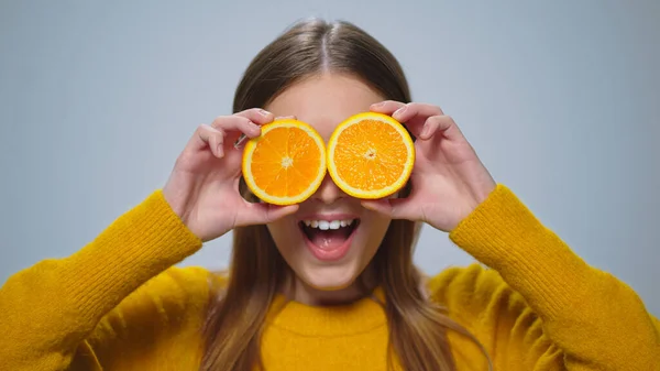 รูปภาพของผู้หญิงที่มีความสุข มีความสนุกสนานกับสองส้มชิ้นในสตูดิโอ . — ภาพถ่ายสต็อก