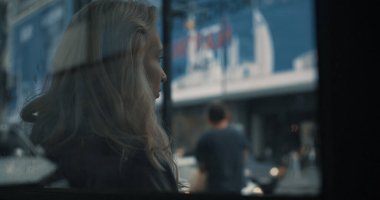 Şehir merkezindeki caddede toplu taşıma istasyonunda oturan kız.. 