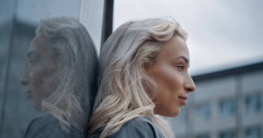 Şehir merkezindeki kentsel binalara bakan kadın profili. 