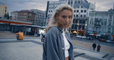 Alacakaranlık modern şehir ışıklarında poz veren çekici kadın model.. 