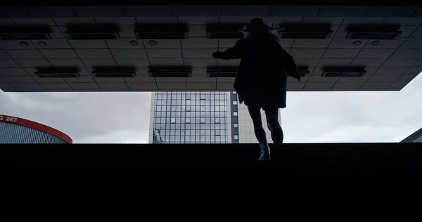 Femme montant les escaliers de la station de métro sombre du centre-ville. — Photo
