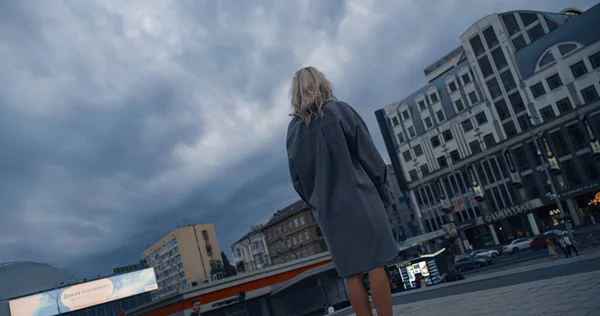 혼자 서 저녁 거리 불빛에 도시 풍경에서 구름을 보고 있는 여자. — 스톡 사진