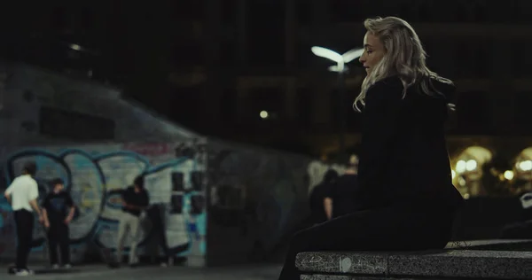 Menina atraente andando cidade em roupas casuais em edifícios urbanos à noite. — Fotografia de Stock