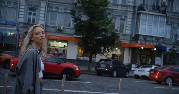 Lycklig kvinna promenader stad vid sen kväll på urban bakgrund. — Stockfoto