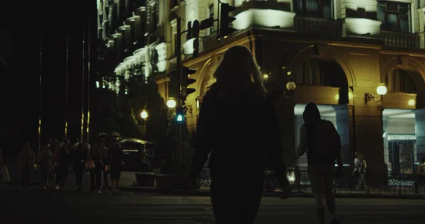 Mujer cruzando la calle noche en el paso de peatones en el centro de la ciudad luces. — Foto de Stock