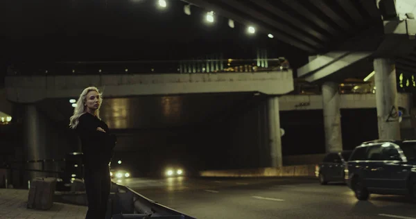 혼자 서 차들 이 운전하는 터널을 지나는 모습을 바라보며 고속 도로에서 있는 소녀. — 스톡 사진