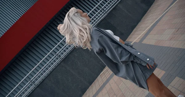 도시 중심가에 있는 현대 도시 건물 근처에 있는 모델 소녀의 모습. — 스톡 사진