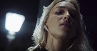 Şehirli kız yüzü şehrin arka planındaki gece ışıklarına bakıyor.. 