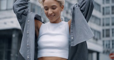 Şehirde poz veren kadın model kamera kentsel arka planda yürüyor. 