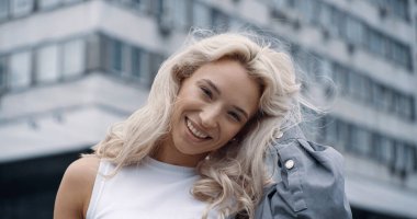 Şehir merkezindeki şehir binalarında gülümseyen mutlu model.. 