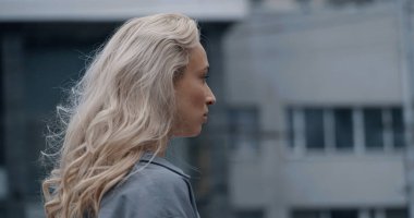 Şehrin arka planında modern binaya bakan şehir kadını.. 