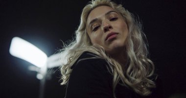 Gece gökyüzünde şehir ışıklarında fotoğraf çekmek için poz veren genç kız.. 