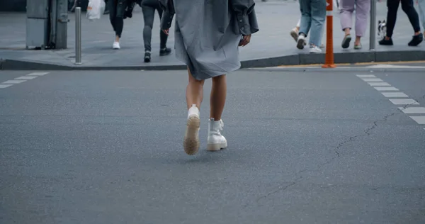 Chica piernas cruzar la calle en el paso de peatones en la ciudad calle del centro. — Foto de Stock