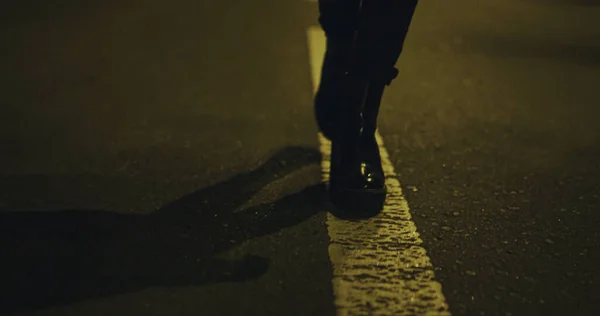 Mujer caminando piernas noche sola en la carretera de la ciudad. Chica va piernas en zapatos. — Foto de Stock