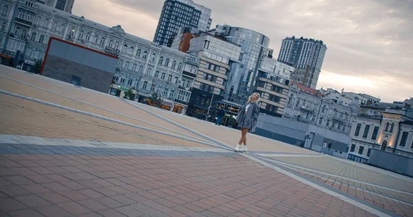 Mujer de pie sola ciudad en el centro al atardecer luces de la calle. — Foto de Stock