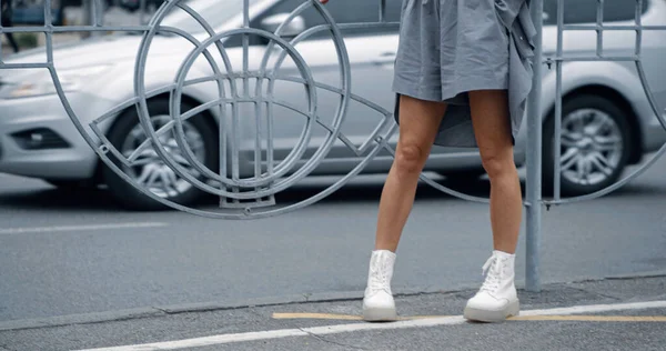 Caucásico mujer piernas de pie en ciudad fondo carretera carretera. — Foto de Stock