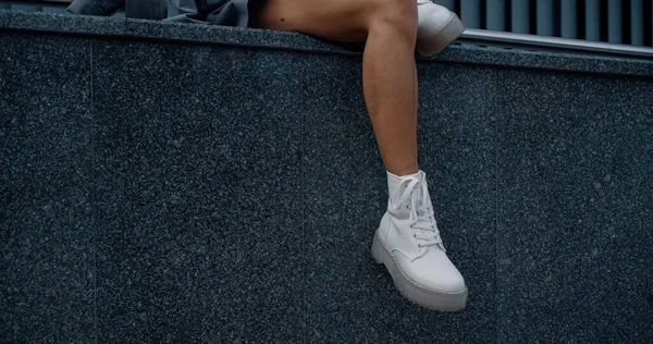 Ноги жіночої моделі сидять позує в міському будівництві міста в центрі . — стокове фото