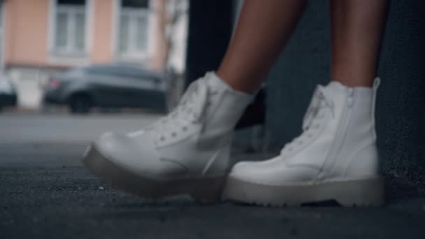Kaukasisch meisje stedelijke schoenen staan in de stad achtergrond modern gebouw. — Stockvideo
