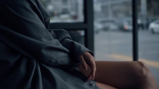 Mulher sentado estação de ônibus na área urbana perto da estrada durante o dia. — Vídeo de Stock