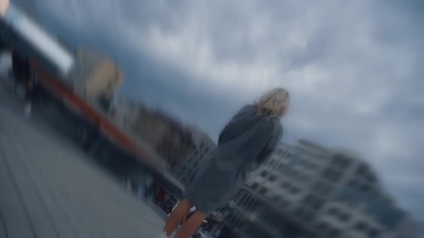 Samotna kobieta ogląda chmury w krajobrazie miasta w wieczornych światłach ulicznych. — Wideo stockowe