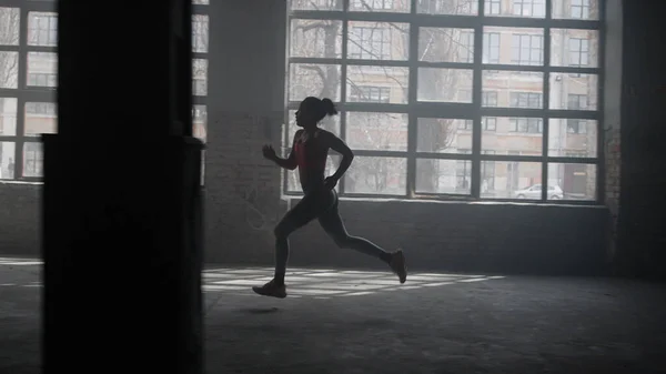 体育館のスタート地点に立つスポーツ女性。ロフトビルで走る選手 — ストック写真