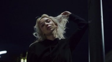 Sarışın kadın gece yarısı şehir ışıklarında poz veriyor.. 