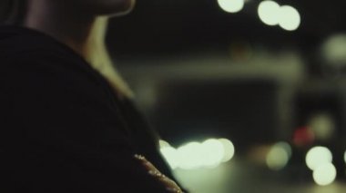 Kadın, gece kentiyle yüzleşiyor. Düşünceli bir şekilde şehir planına bakıyor.. 