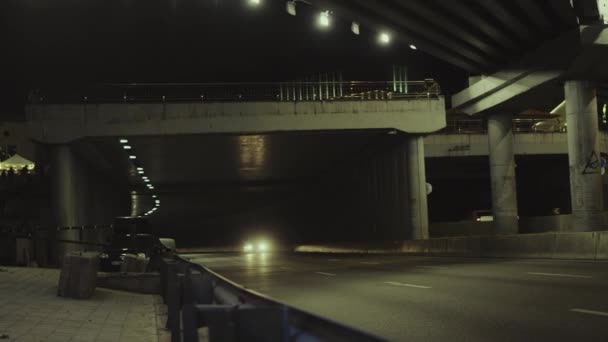 City most noční auta procházející podzemní tunel v městském pozadí. — Stock video