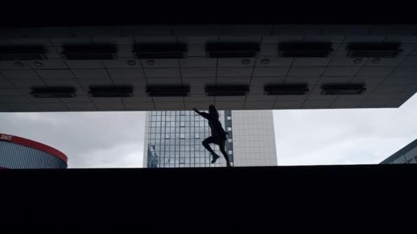 Silhueta pessoa feminina pulando na estação subterrânea escura ou estacionamento. — Vídeo de Stock