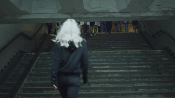 Jonge vrouw gaat trappen in de stad draagt stedelijke kleding op straat. — Stockvideo