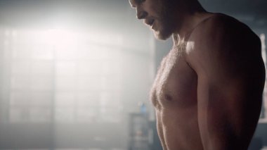 Powerlifter halter egzersizi yapıyor. Çıplak gövdeli bir adam ağırlık kaldırıyor. 