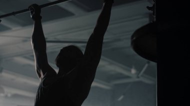 Spor salonunda barfiks çeken bir adam. Fitness kulübünde yatay barda sporcu eğitimi.