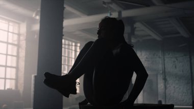 Ahşap kutuda karın kasları eğitimi alan bir kadın. Atletizm karın kaslarını çalıştırıyor