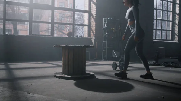 Жінка стрибає на дерев'яній коробці в спортзалі. Дівчина робить глибокі присідання зі стрибками — стокове фото