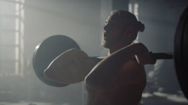Erkek kaldırıcı beden eğitimi için hazırlanıyor. Çığlık atan adam ağırlık kaldırıyor.