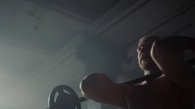 Kaba adam ters tutuş halteri kıvırma egzersizi yapıyor. Güçlü adam ağırlık kaldırıyor.