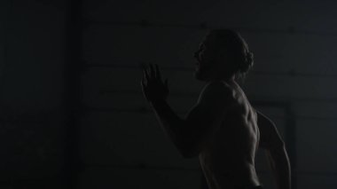 Atletik adam çatı katında hızlı koşuyor. Sporcu spor salonunda kardiyo çalışması yapıyor.