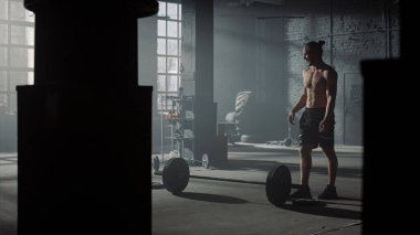 Genç sporcu spor kulübünde halter kaldırmadan önce ağırlık kontrolü yapıyor.